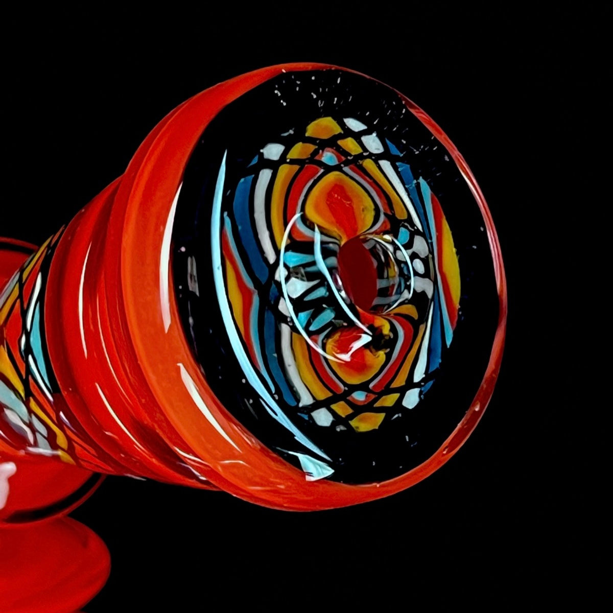 Red and clear glass smoking device with colorful designs on a white background.