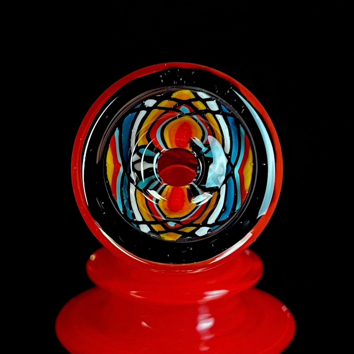 Red and clear glass smoking device with colorful designs on a white background.