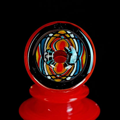 Red and clear glass smoking device with colorful designs on a white background.