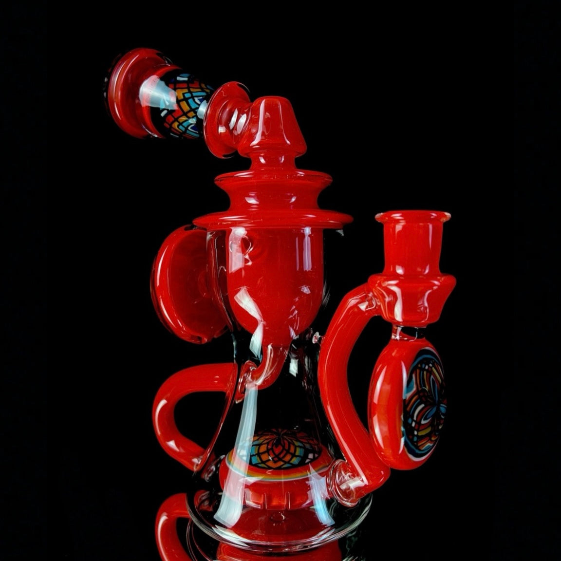 Red and clear glass smoking device with colorful designs on a white background.