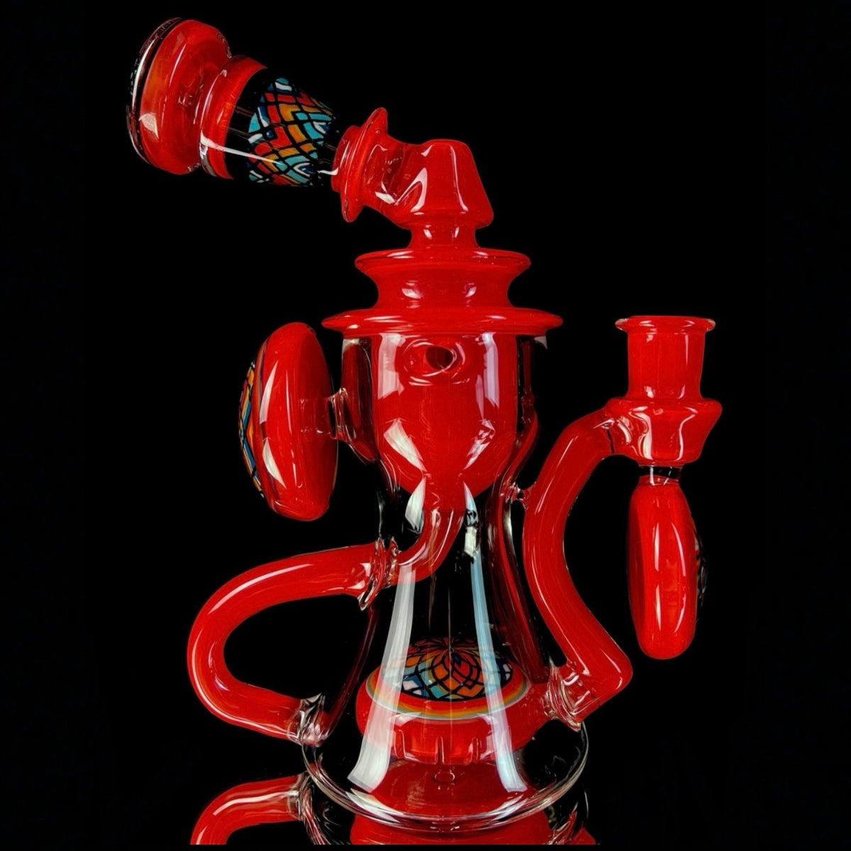 Red and clear glass smoking device with colorful designs on a white background.