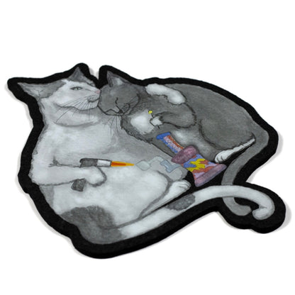 A decorative moodmat featuring a design with two cartoon cats and a colorful object.