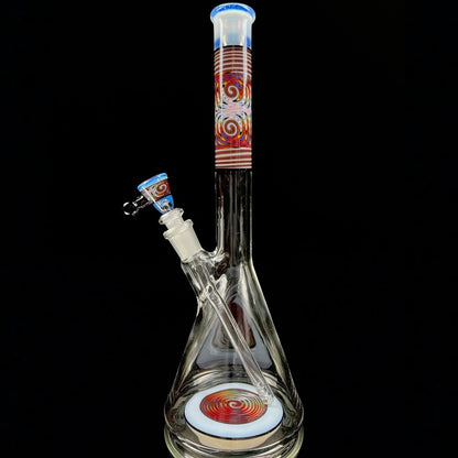A tall, clear glass beaker with a colorful geometric pattern near the top, featuring a removable down stem and a 3-hole slide.