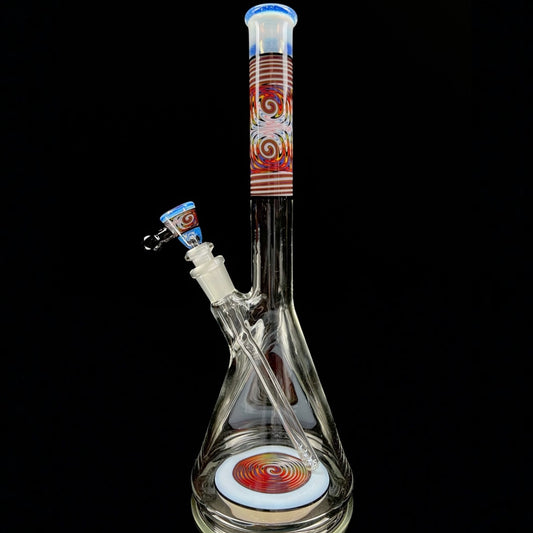 A tall, clear glass beaker with a colorful geometric pattern near the top, featuring a removable down stem and a 3-hole slide.