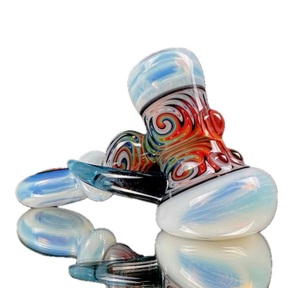A handcrafted glass hammer with a unique design, featuring predominantly white glass with multicolored patterns and swirls, and a distinctive bulbous shape.
