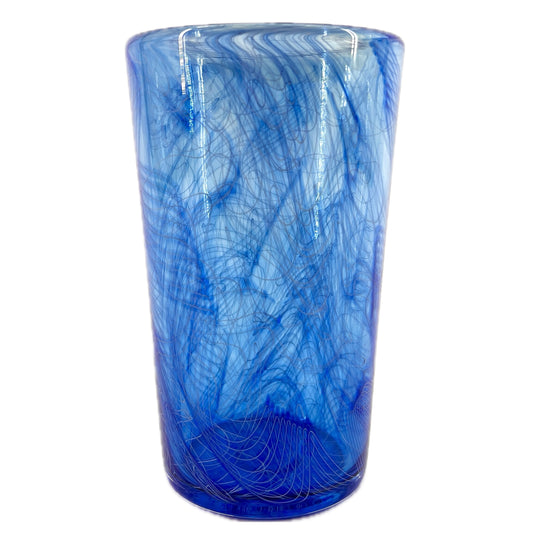 A cylindrical, blue glass pint with a swirling pattern, crafted from glassblowing.