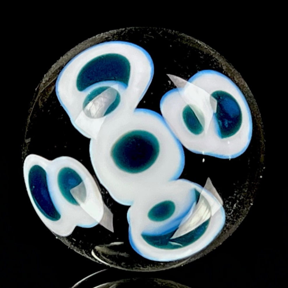 A multicolored glass marble with a design resembling a flower with blue petals on a white background, with a diameter approximately of 22mm.