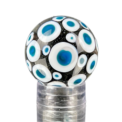 A glass marble with a design of blue dots on a white background, approximately 26mm in diameter.