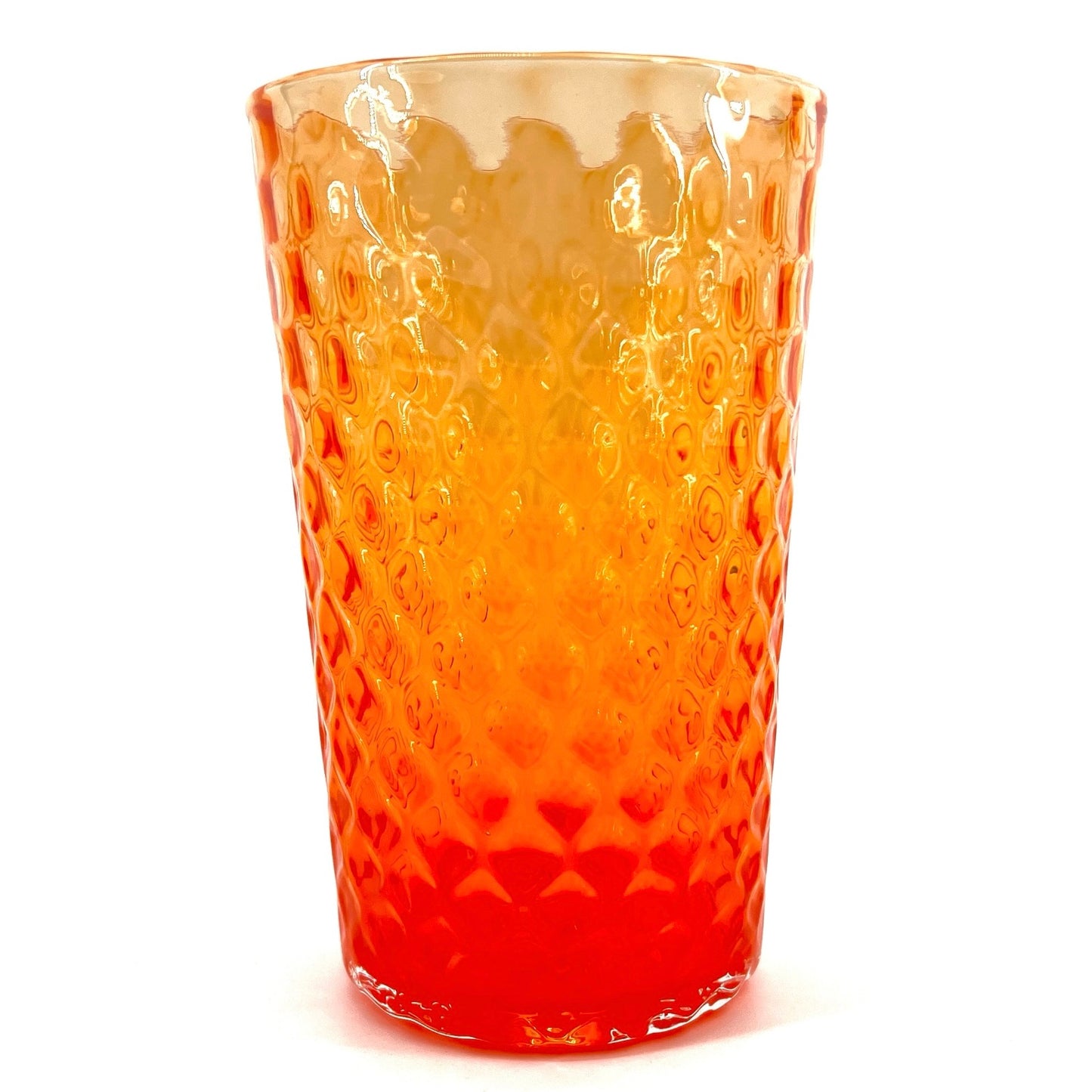 A hand-blown glass with an orange color and a textured surface, crafted by Xander D’Ambrosio.