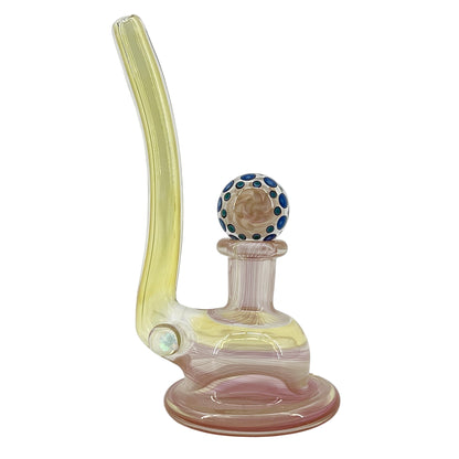 Glass smoking device with a yellow neck and colorful marble on a white background