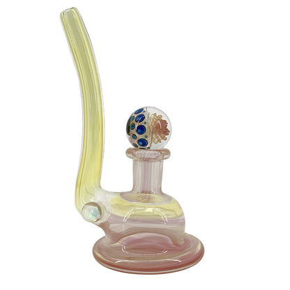 Glass smoking device with a colorful marble on a white background