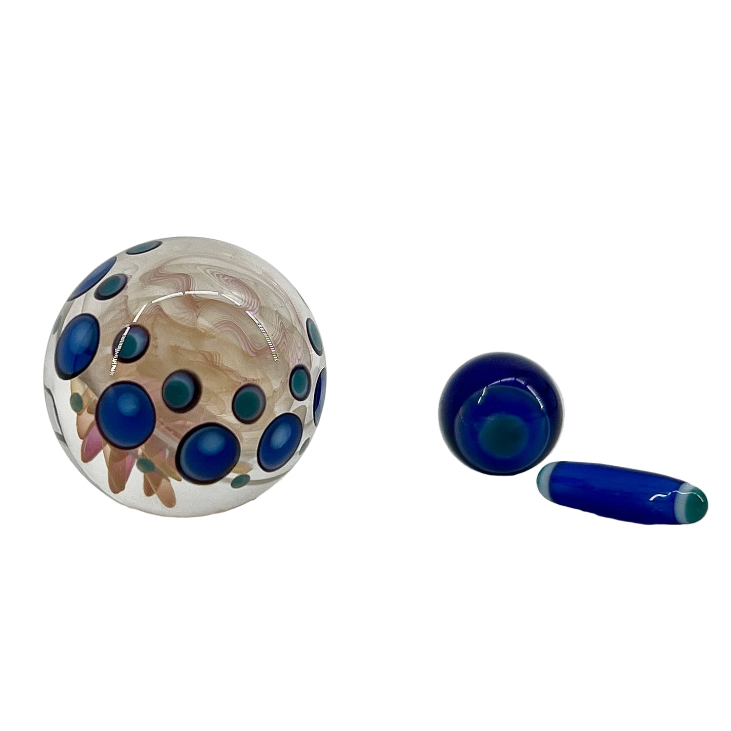 Three glass objects with blue and green patterns on a white background