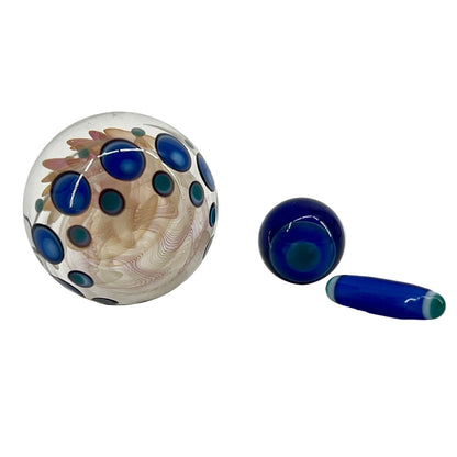 Three glass objects with blue and green patterns on a white background.