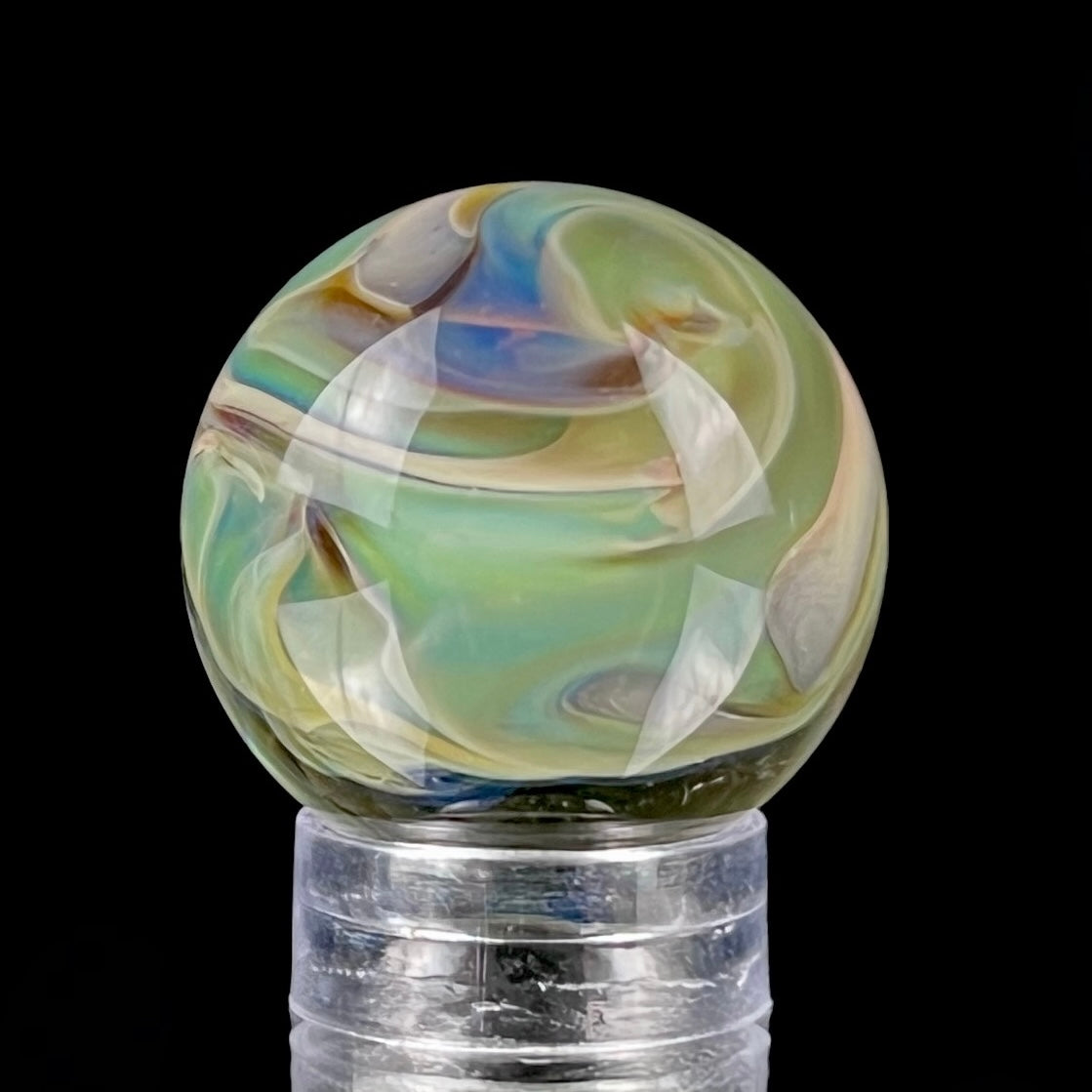 A multicolored glass marble with earth tones, placed on a glass stand.