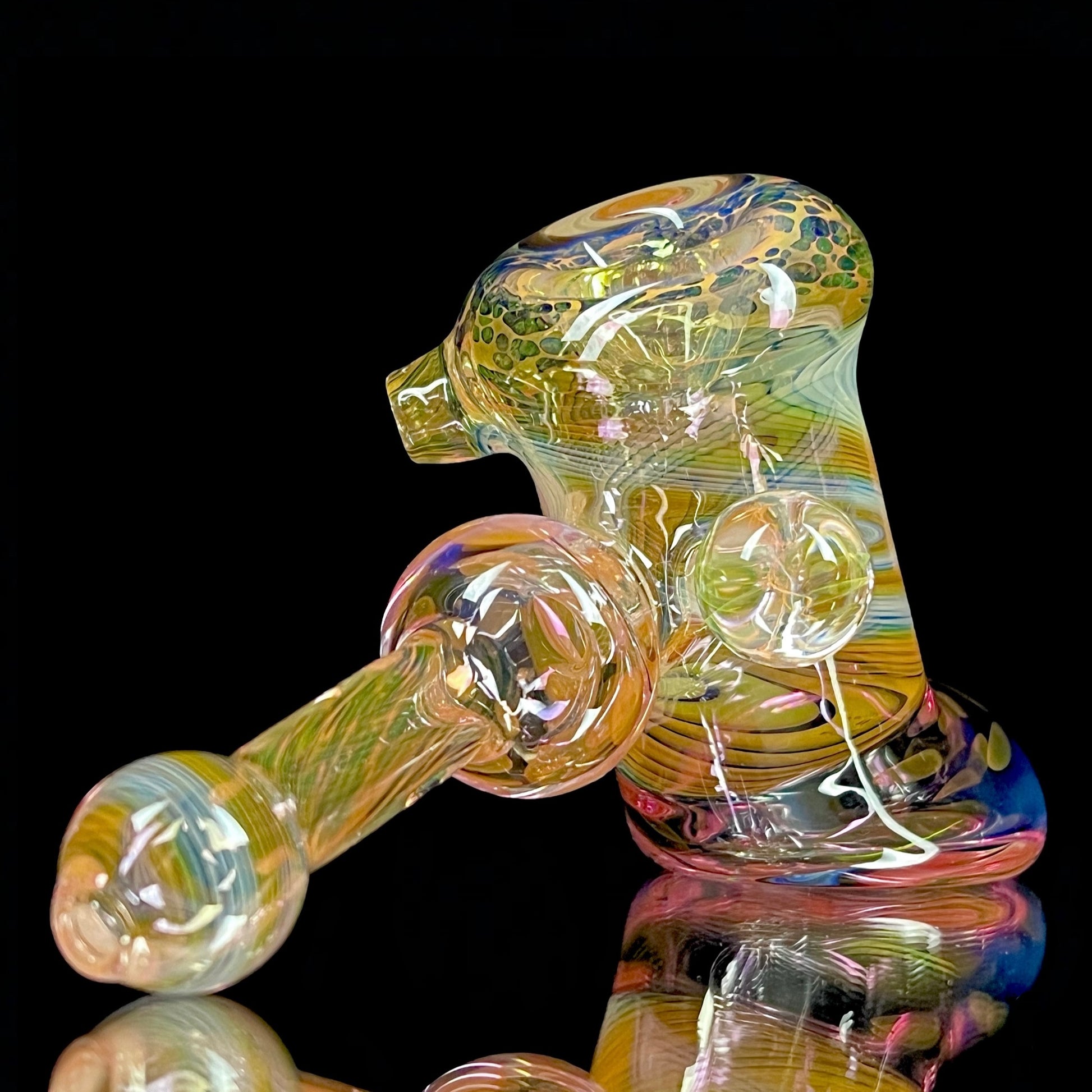 A multicolored glass hammer-style pipe with intricate patterns and a round bowl.