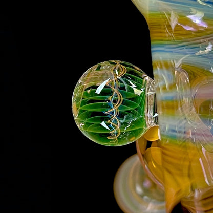 A close up of a multicolored glass hammer-style pipe with intricate patterns and a round bowl.