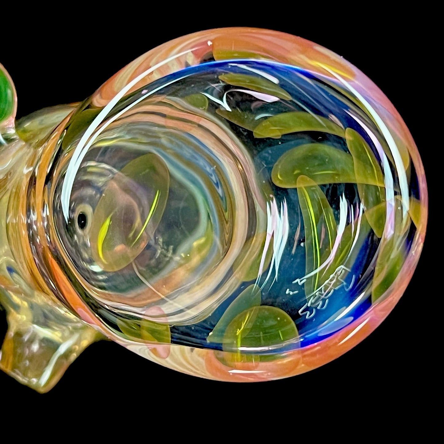 A close up of a multicolored glass hammer-style pipe with intricate patterns and a round bowl.