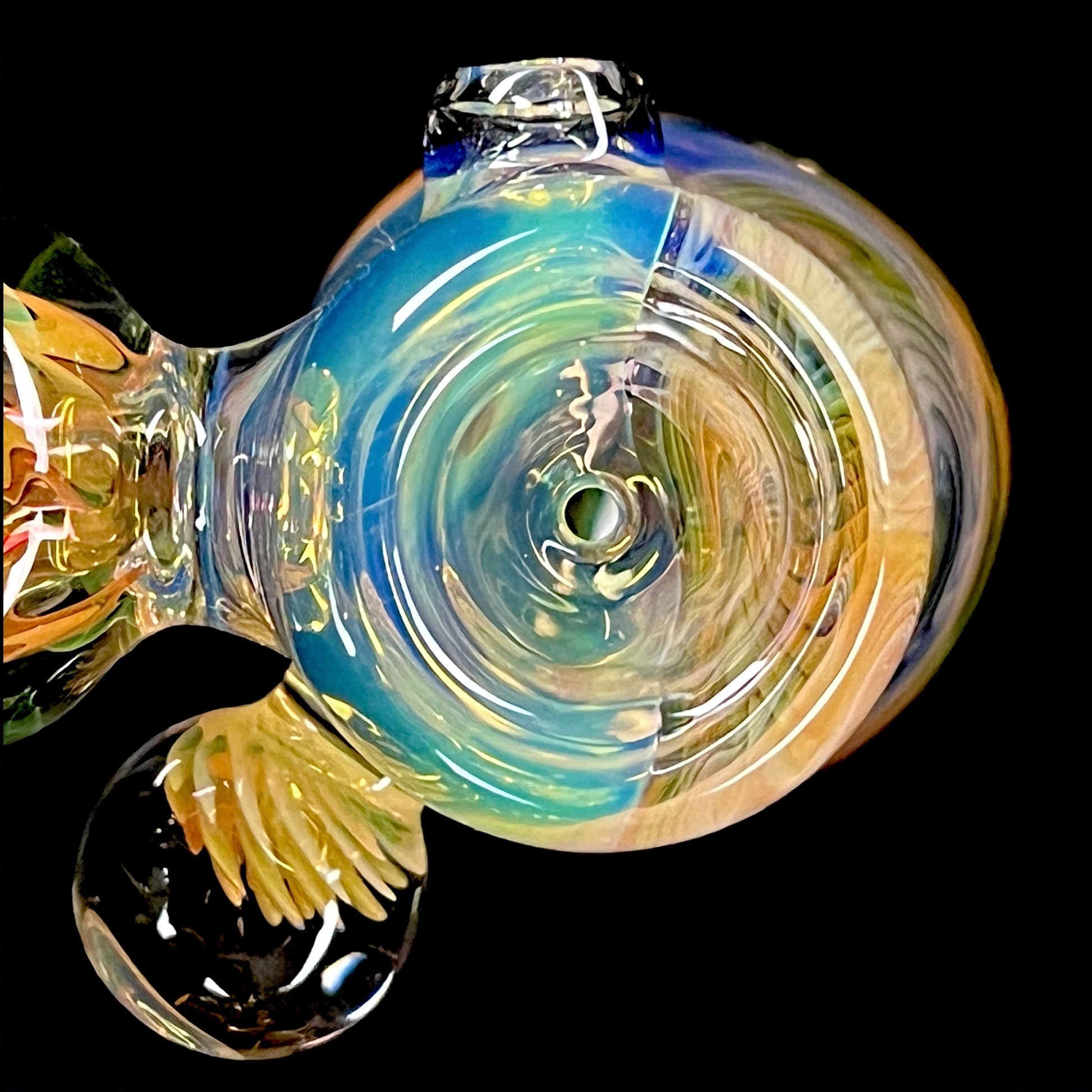 A colorful glass hammer-shaped piece with blue, gold, and silver fume patterns.