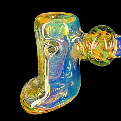 A colorful glass hammer-shaped piece with blue, gold, and silver fume patterns.
