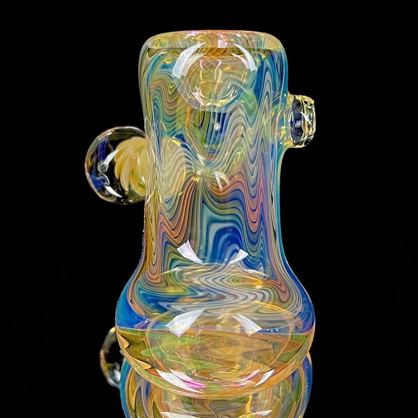 A colorful glass hammer-shaped piece with blue, gold, and silver fume patterns.