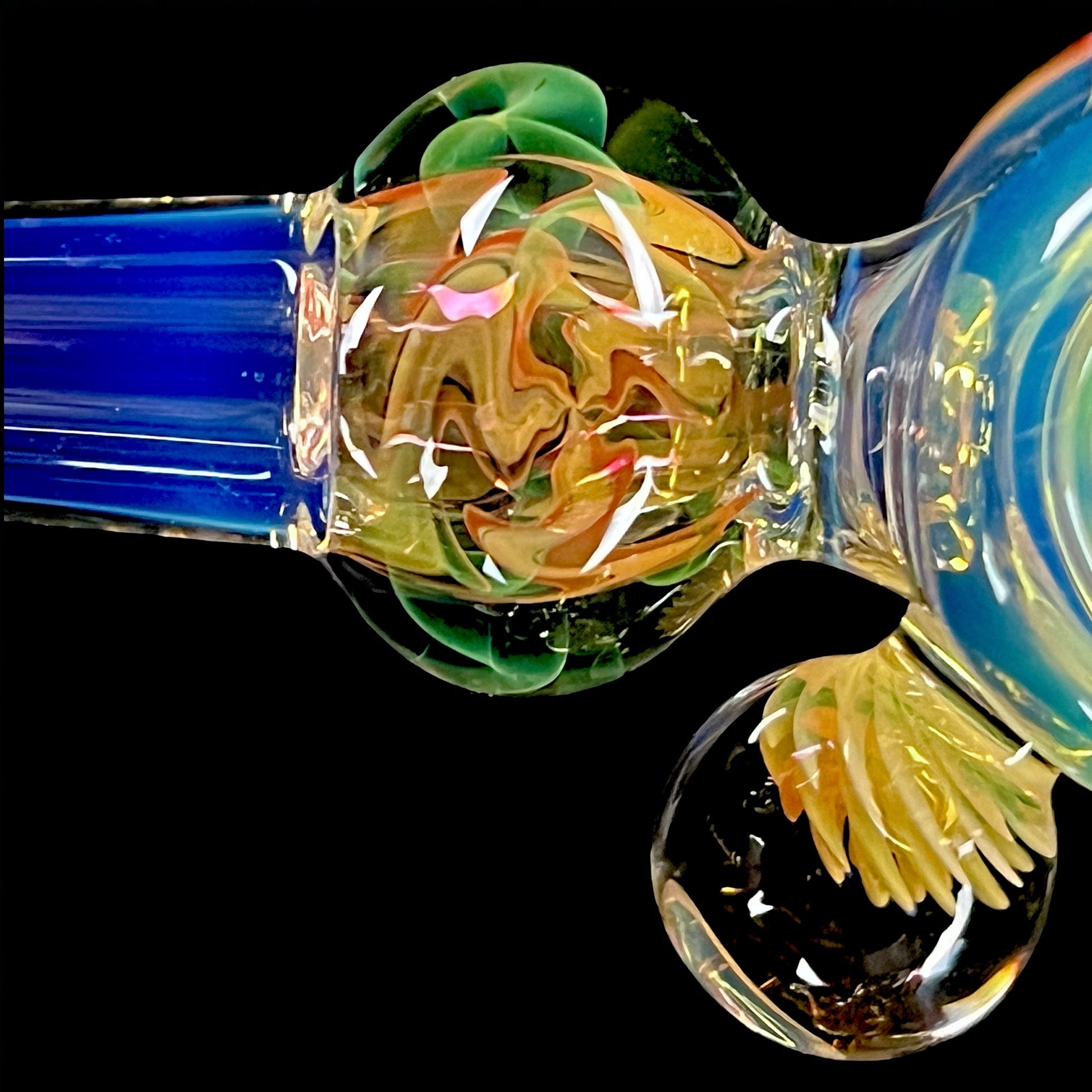 A colorful glass hammer-shaped piece with blue, gold, and silver fume patterns.