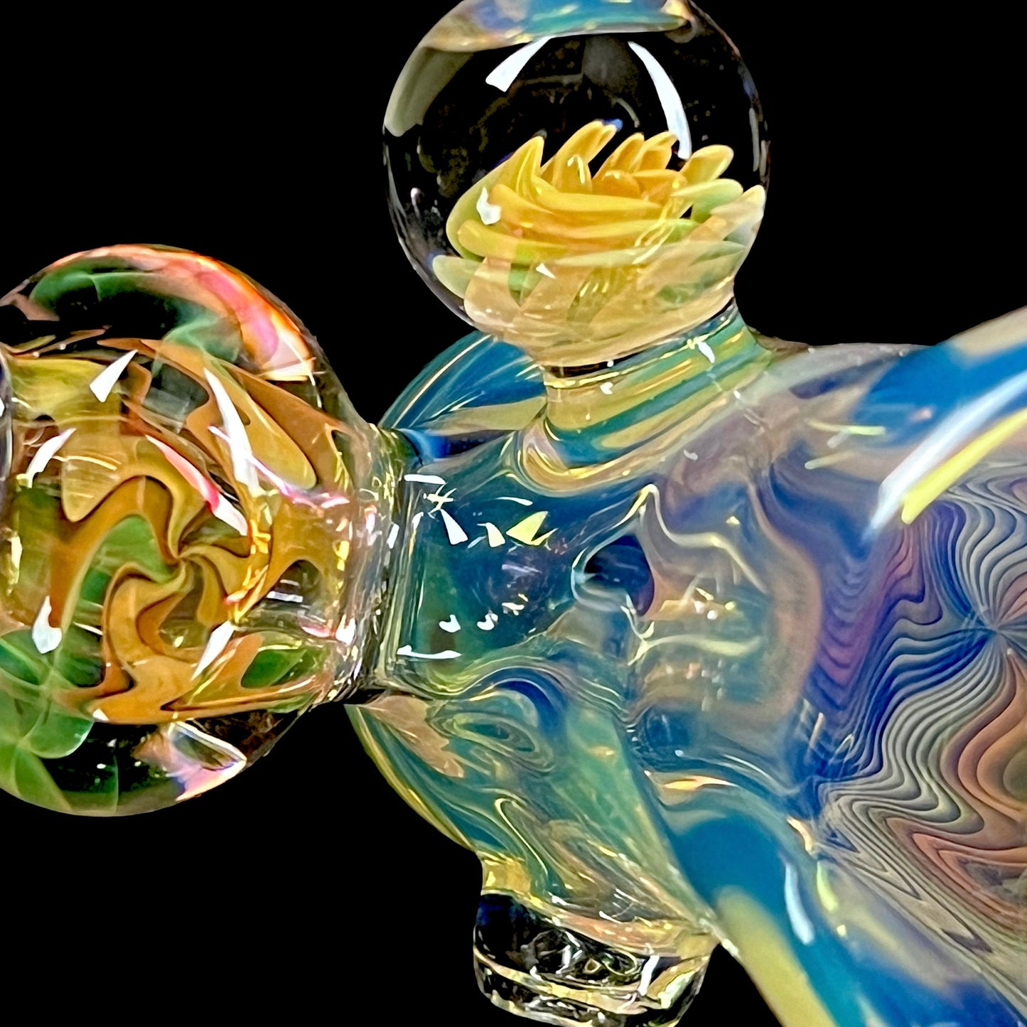 A colorful glass hammer-shaped piece with blue, gold, and silver fume patterns.