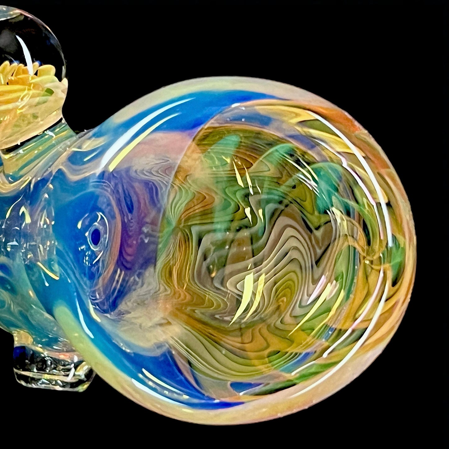A colorful glass hammer-shaped piece with blue, gold, and silver fume patterns.