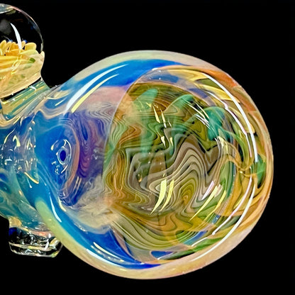 A colorful glass hammer-shaped piece with blue, gold, and silver fume patterns.
