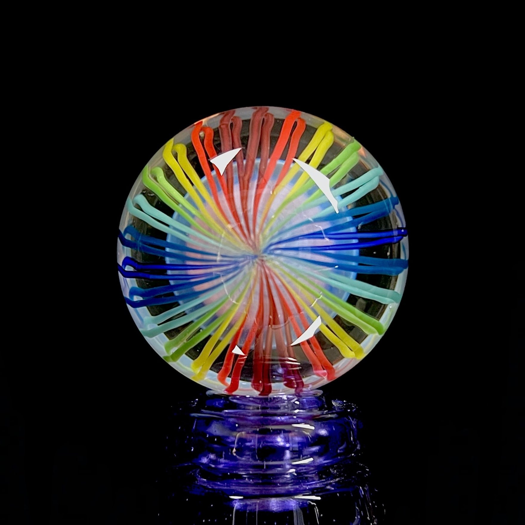 A multicolored glass marble with pinwheel-like linework.