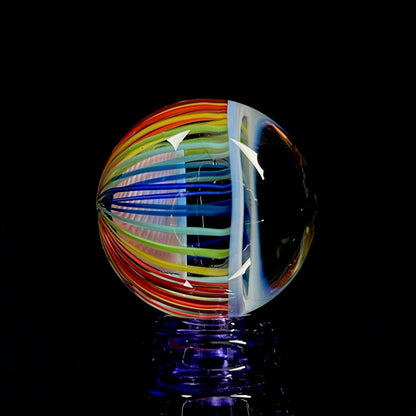 A multicolored glass marble with pinwheel-like linework.