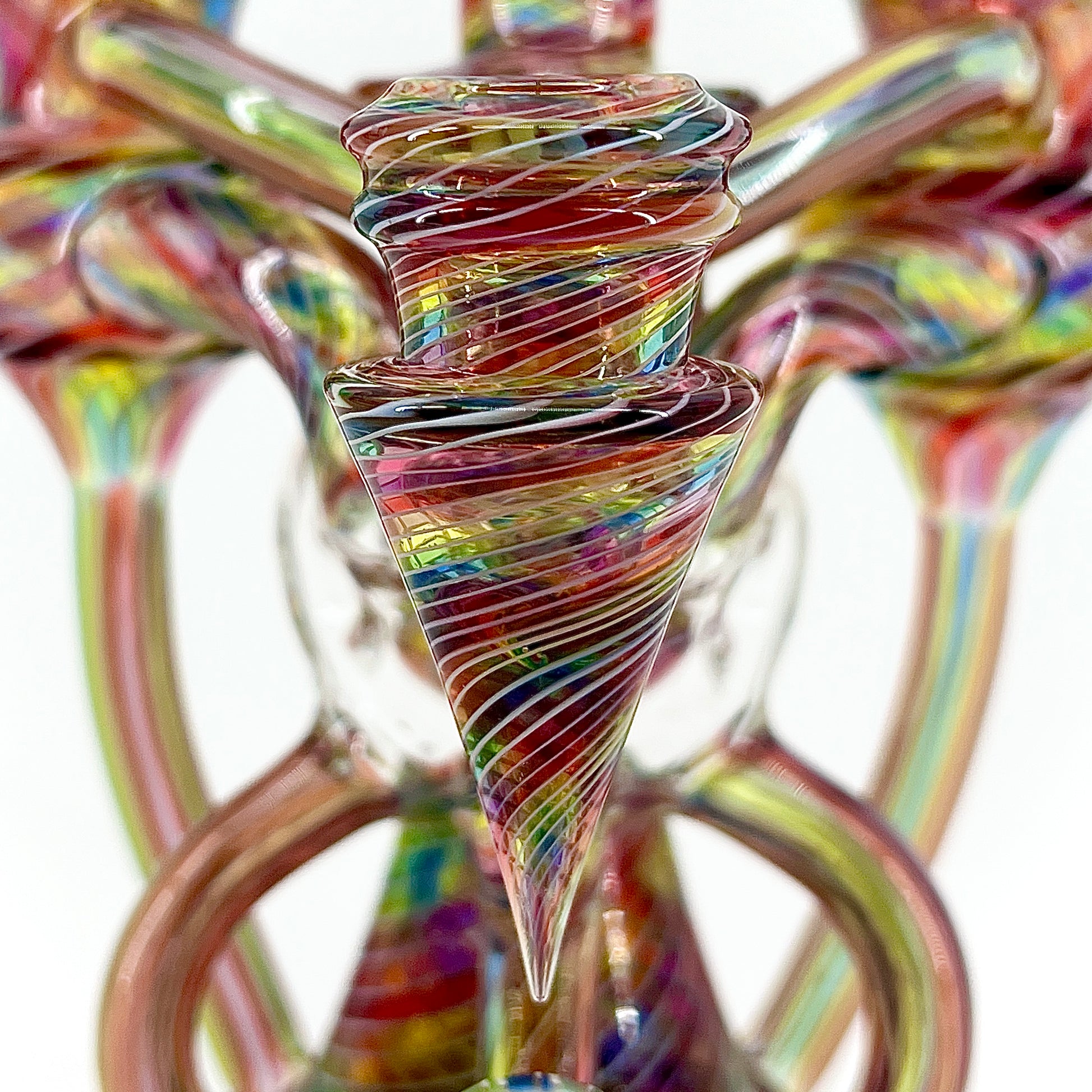 Colorful glass sculpture with a spiral design on a white background.