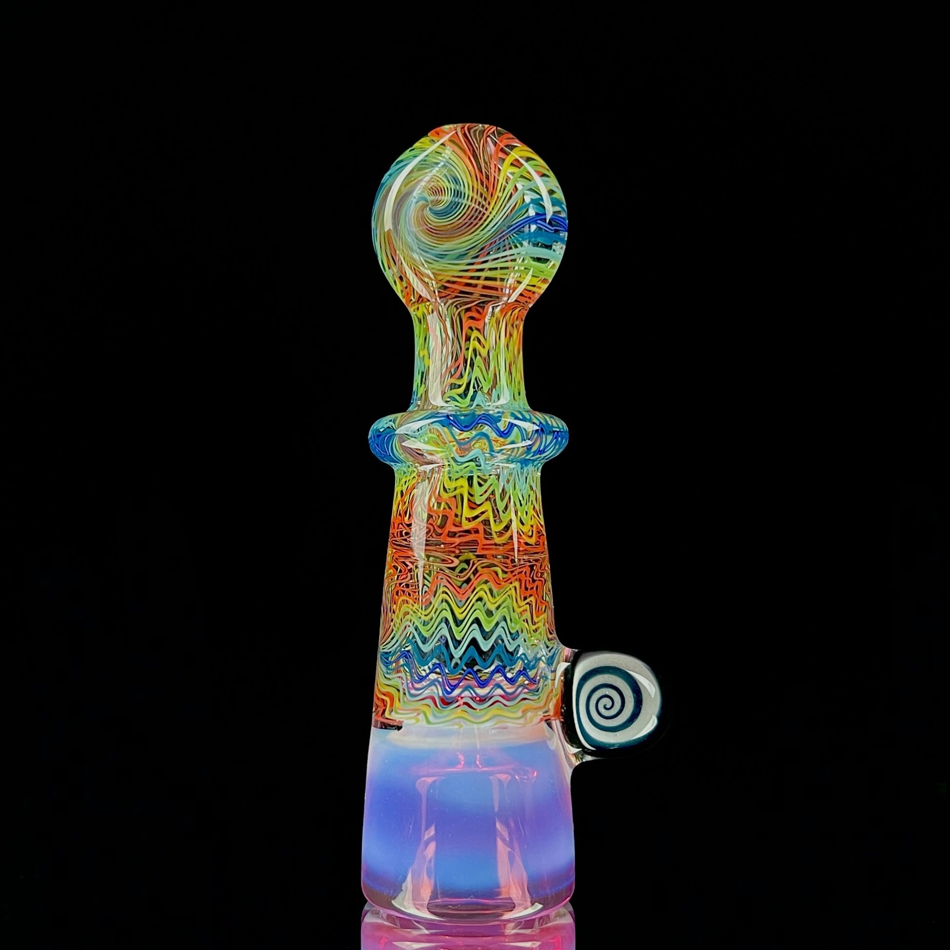 A multicolored glass piece with an intricate pattern, featuring a bowl on the bottom and a Gold Ruby over Moonstone lip.