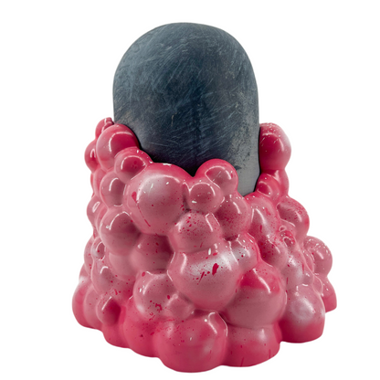 Pink textured object with a gray cylindrical top on a white background.