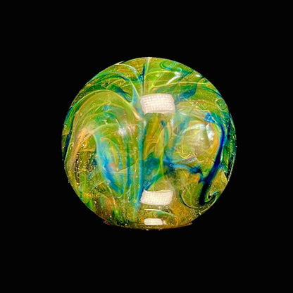 Colorful glass marble with green, blue, and yellow swirls on a black background