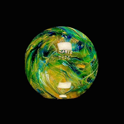 Colorful glass sphere with swirling patterns on a black background