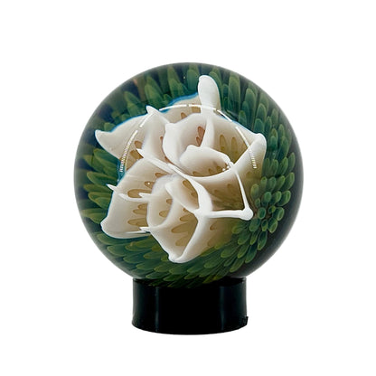 Decorative sphere with white floral design on a green background