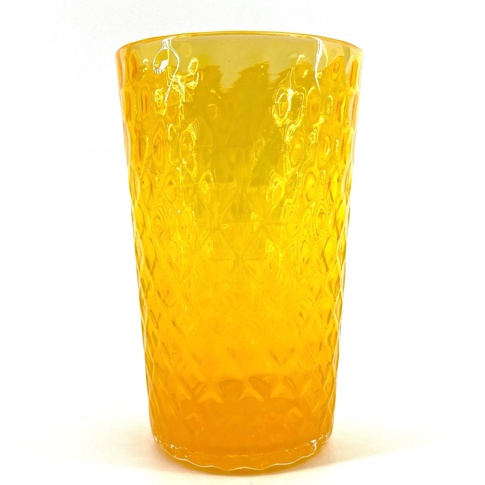A yellow colored glass with a geometric optic pattern.