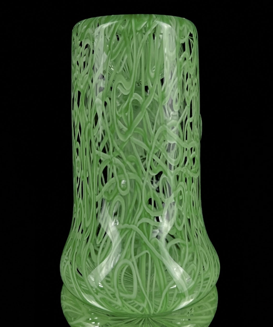 A jade green glass hand pipe with intricate patterns.