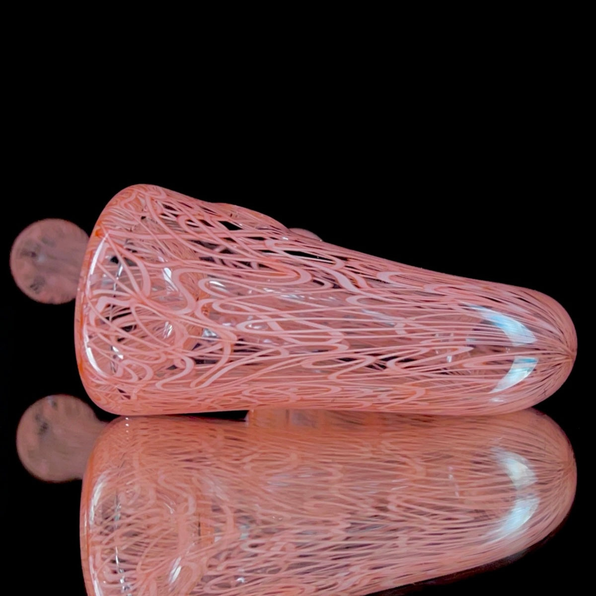 A red glass pipe with a intricate pattern, featuring a bowl and a curved stem.