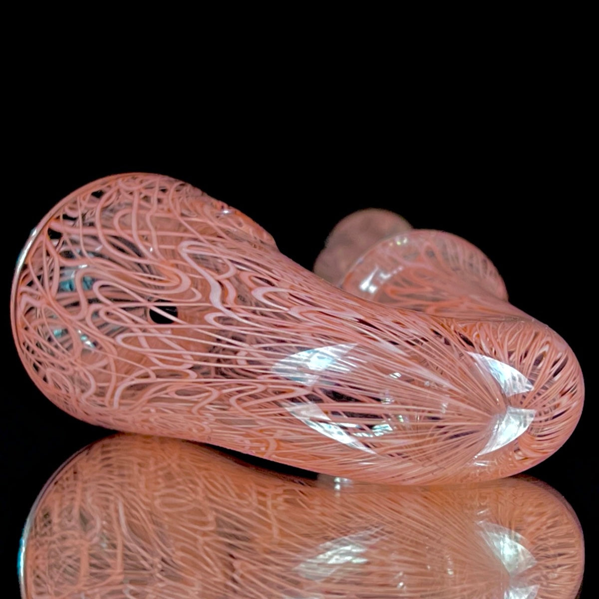 A red glass pipe with a intricate pattern, featuring a bowl and a curved stem.