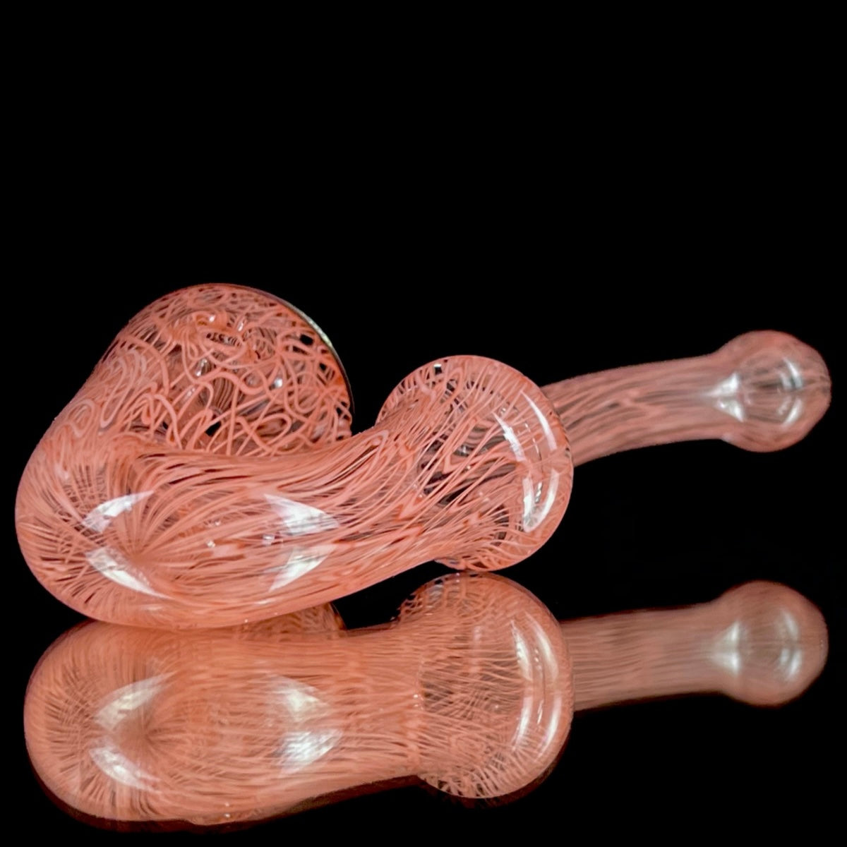 A red glass pipe with a intricate pattern, featuring a bowl and a curved stem.
