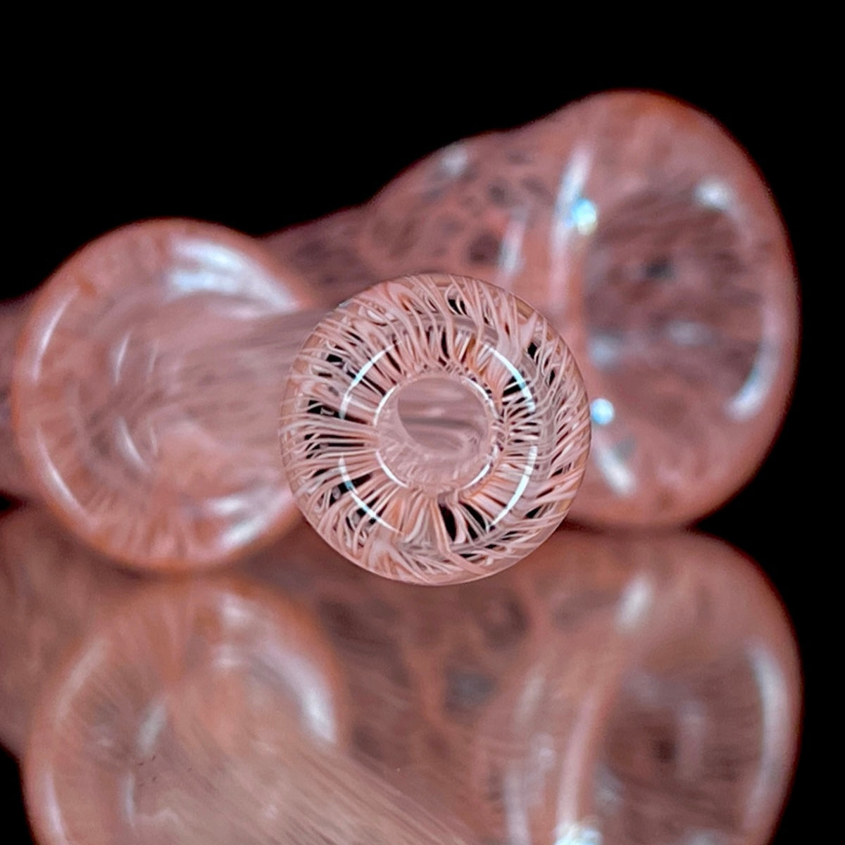 A red glass pipe with a intricate pattern, featuring a bowl and a curved stem.