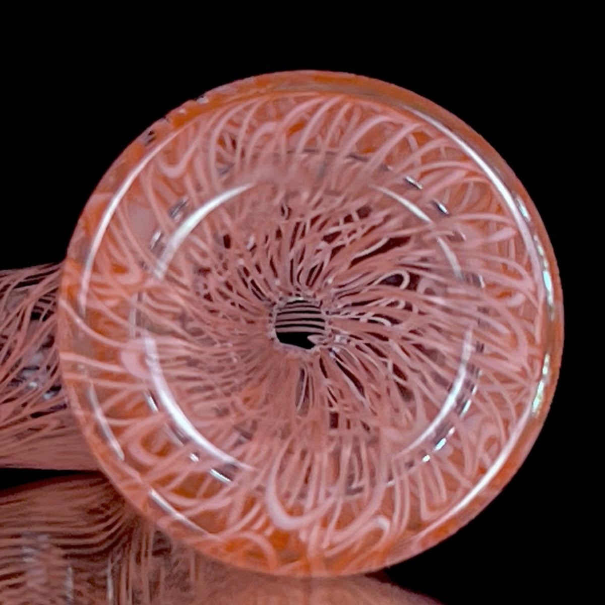 A red glass pipe with a intricate pattern, featuring a bowl and a curved stem.