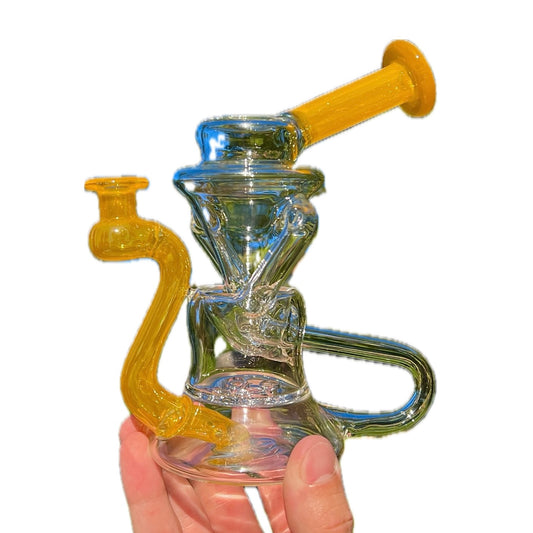 A colorful glass hand pipe with a 4-hole perc and accents in yellow, held in a person's hand.