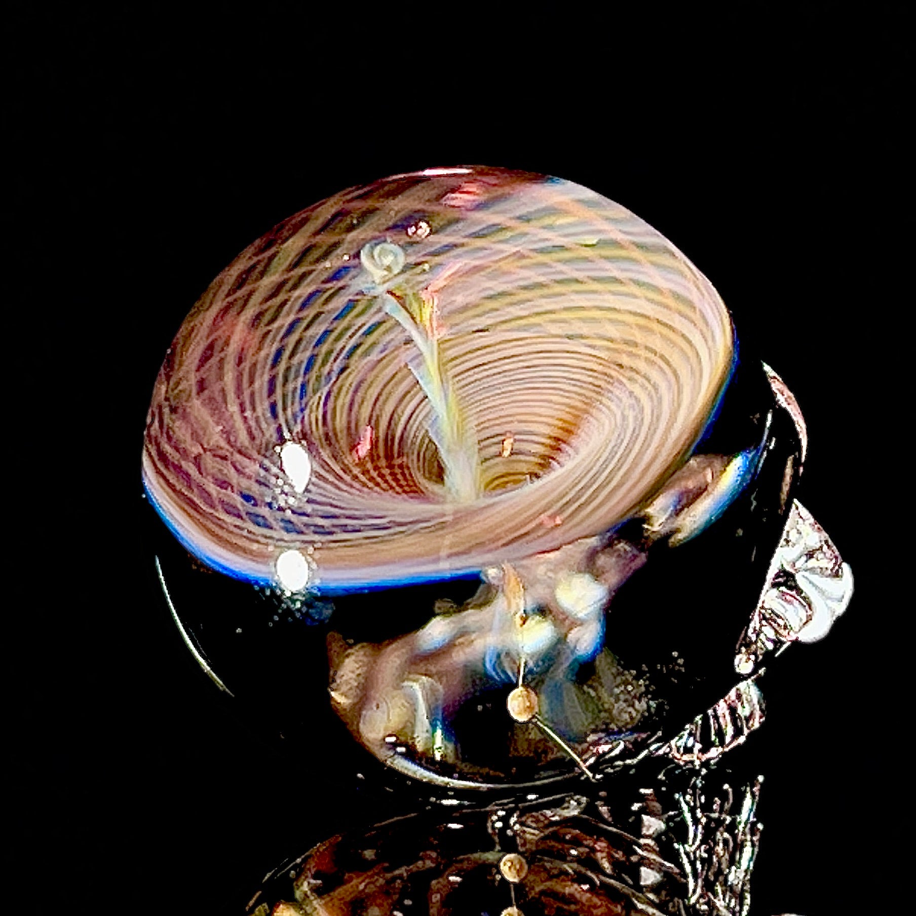 Glass sculpture with multicolored swirls on a black background
