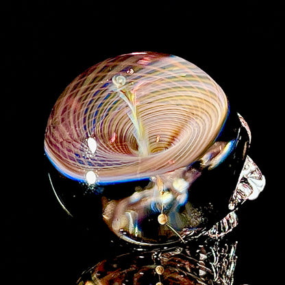 Glass sculpture with multicolored swirls on a black background