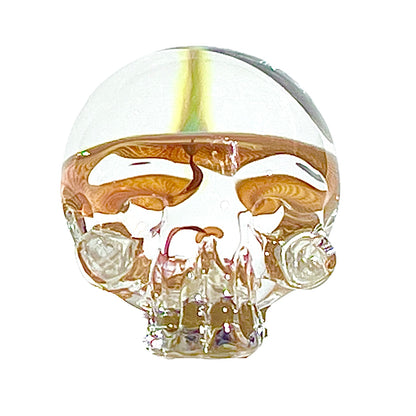 Glass skull paperweight on a white background.