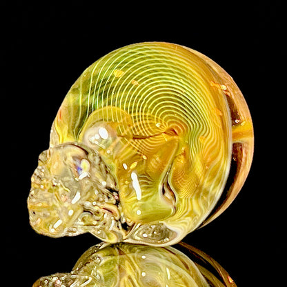 Glass skull with fume spirals on a black background.