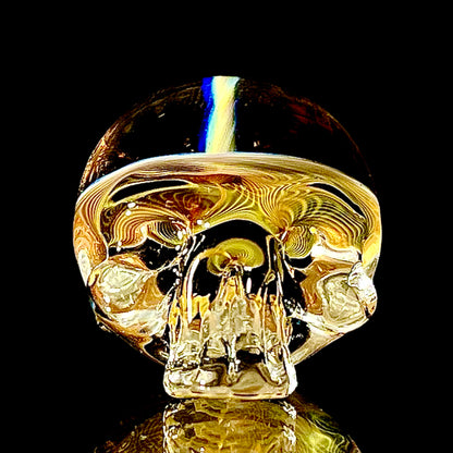 Glass skull paperweight on a black background.