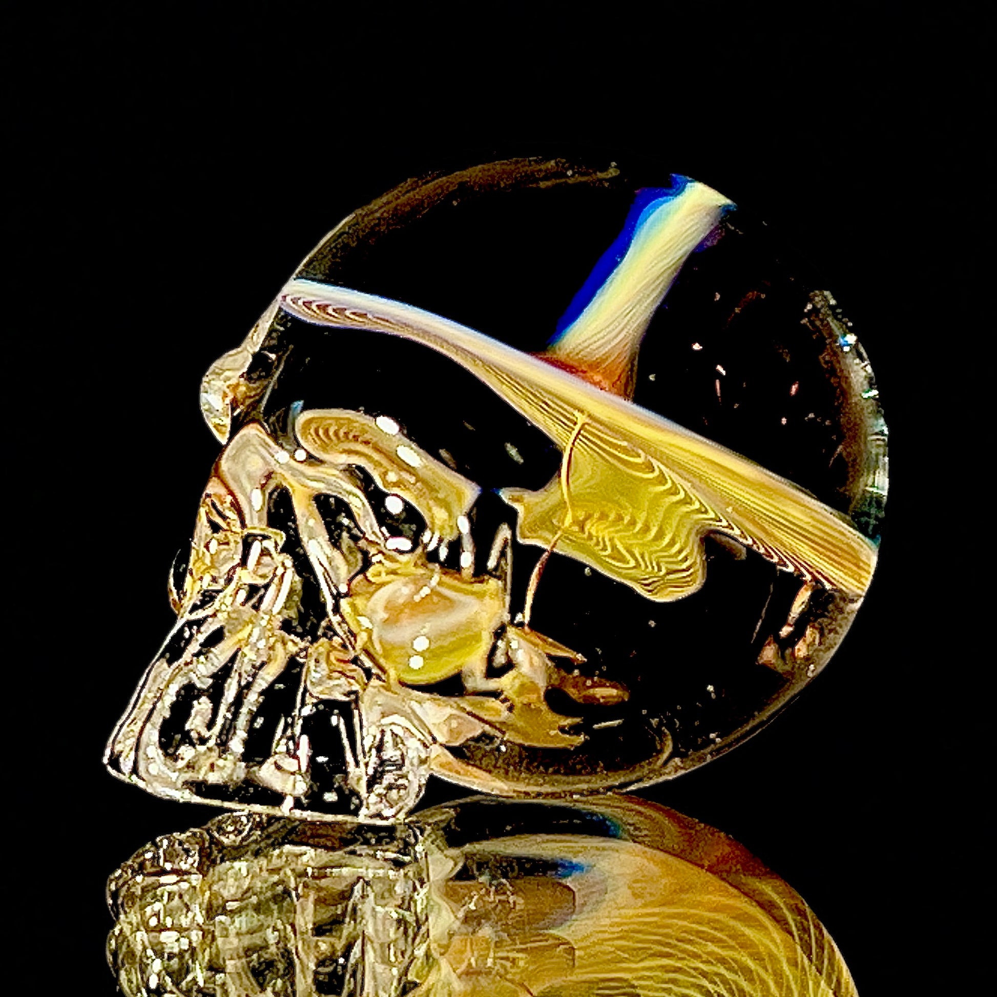 Glass skull paperweight on a black background.
